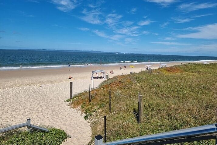 fun-things-to-do-on-the-sunshine-coast Fun things to do on the Sunshine Coast include a relaxed beach day with a sandy path to the shoreline, grassy dunes and calm ocean views